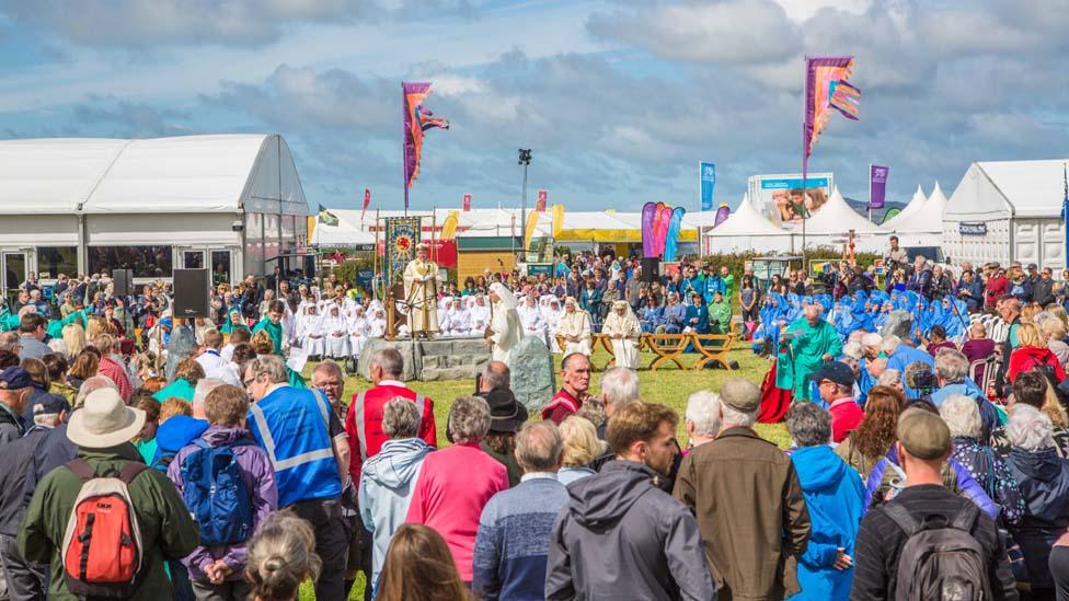 Gwerth straffaglu å'r mwd. beth bynnag, i weld seremoni drawiadol Cylch yr Orsedd. //It was worth wading through the mud to get to the colourful and dramatic Gorsedd of the Bards ceremony - one of the highlights of the National Eisteddfod.