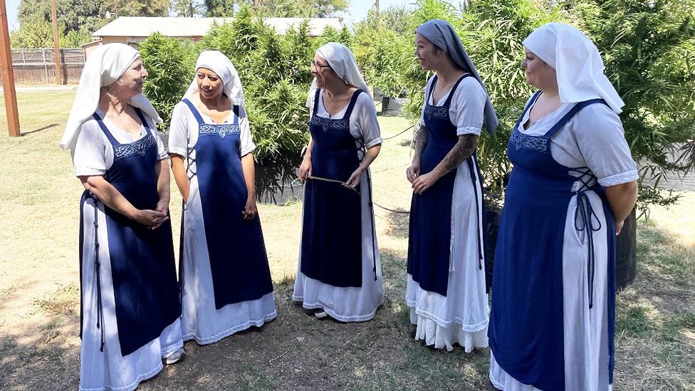 Sisters of the Valley members talk in front of cannabis plants