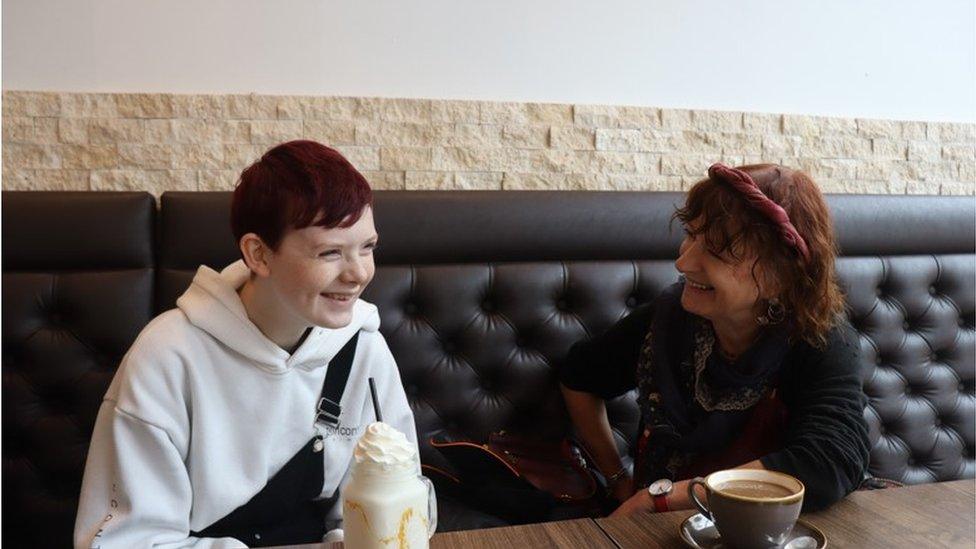 A volunteer mentor with a young person in a cafe