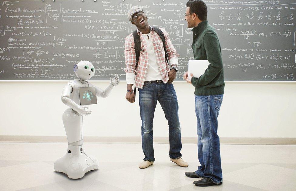 Pepper robot talking to two laughing men