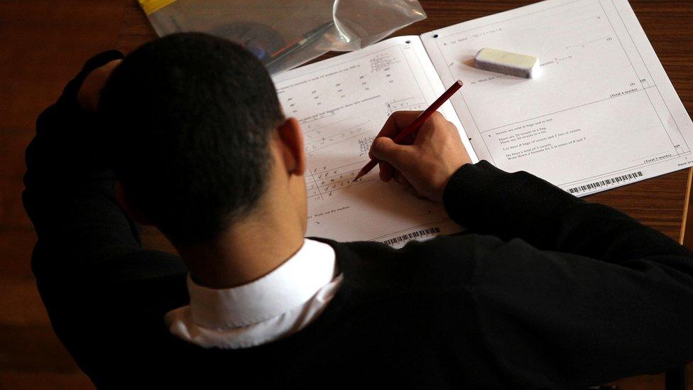 overhead view of boy doing maths exam