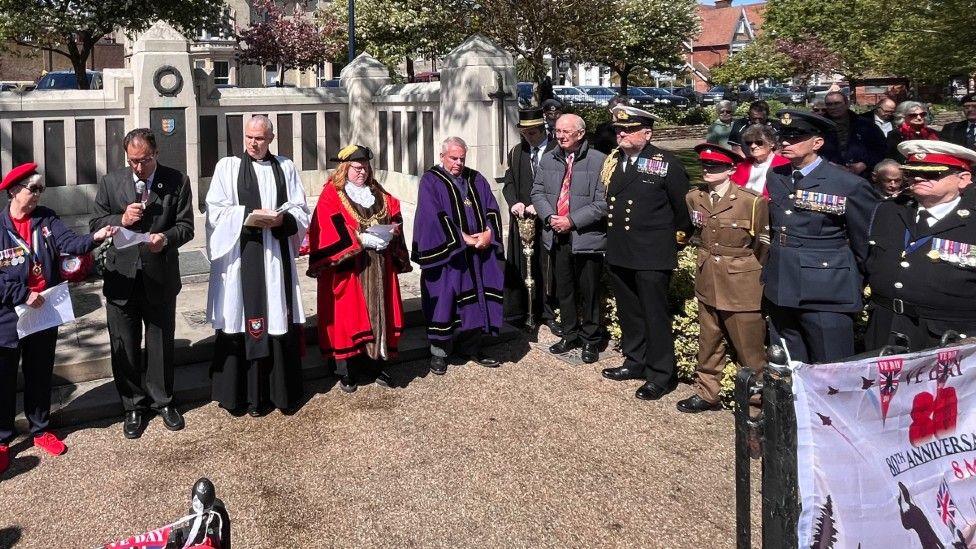 A gathering of people outside a park in Great Yarmouth, including the Mayor, for VE Day.