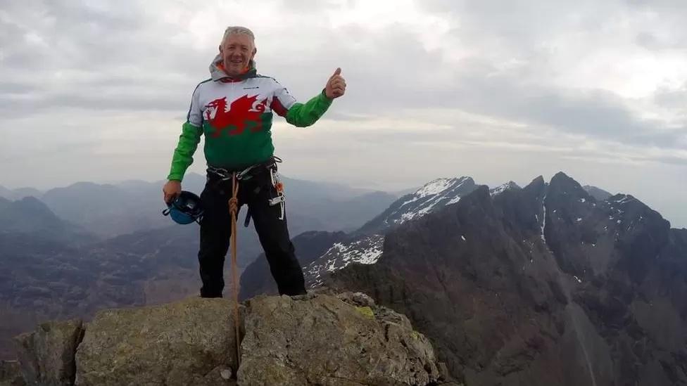 Dafydd Thomas in Welsh flag top climbing