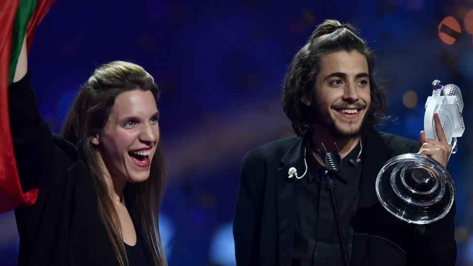 Portuguese singer representing Portugal with the song "Amar Pelos Dios" Salvador Vilar Braamcamp Sobral aka Salvador Sobral (R) holds the trophy as he celebrates with his sister Luisa Sobral on stage after winning during the final of the 62nd edition of the Eurovision Song Contest 2017 Grand Final