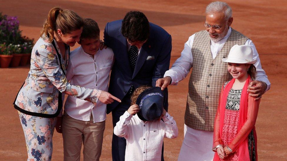 Narendra Modi putting Hadrien's hat in front of his face