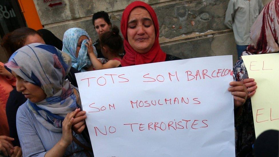 Mother of Aallaa brothers holds a sign next to Hafida Oukabir (sister of suspect Moussa Oukabir) during a Muslim community rally in Ripoll to denounce terrorism