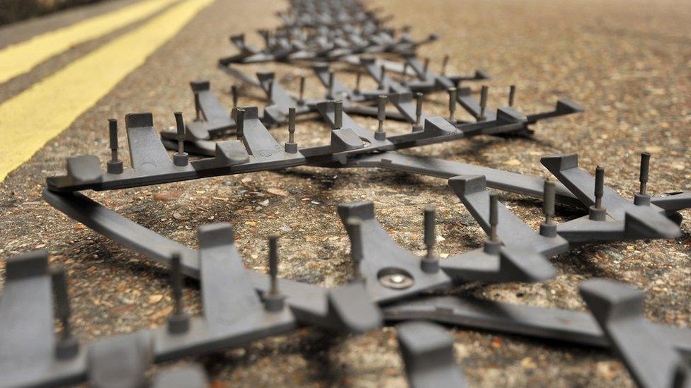 General view of a Police Stinger Spike Strip deployed on a road next to some double yellow lines. 10 October 2013. London UK