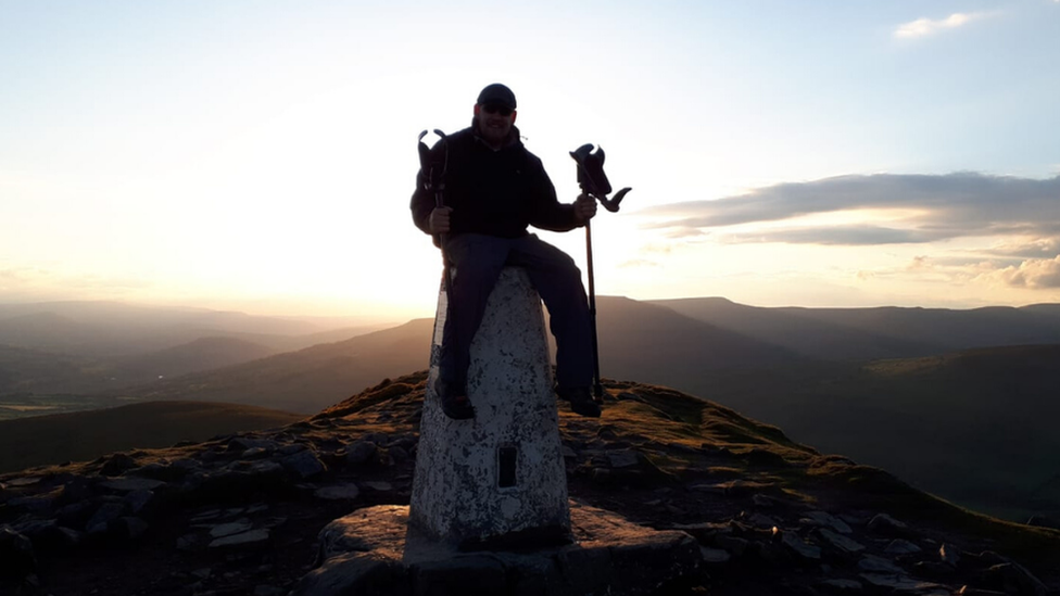 Jamie sat on top of the summit of a mountain