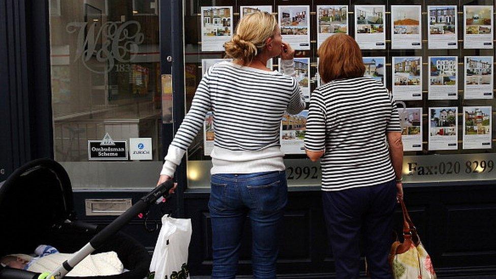 People looking at estate agent's window