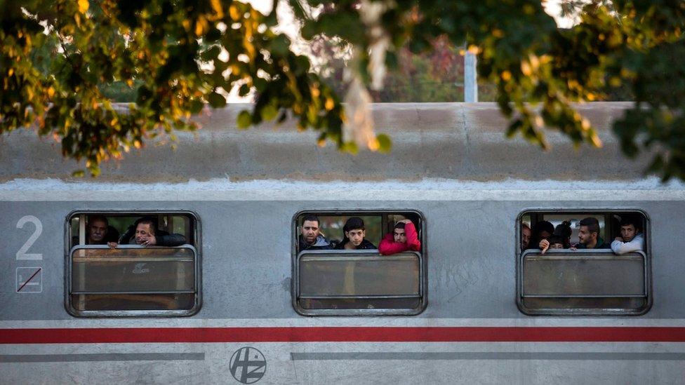 Migrants look from the windows of a train at the railway station in Cakovec, Northern Croatia, Saturday, Oct. 17, 2015.