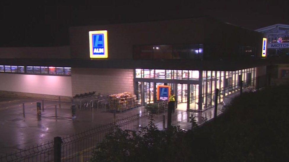 A wider shot of the Aldi store, at night