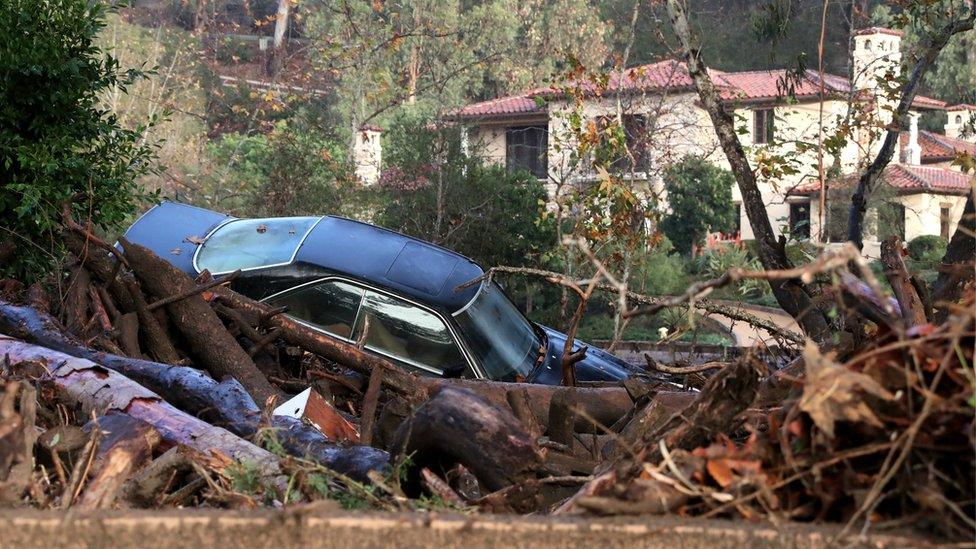 A car is piled up in debris after a mudslide trapped it following heavy rains in Montecito, California.