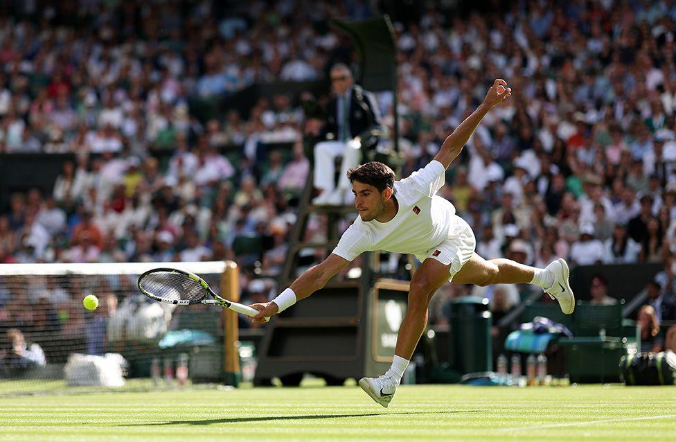 Carlos Alcaraz plays a backhand volley against Oliver Tarvet during the second round of the men's singles at Wimbledon.