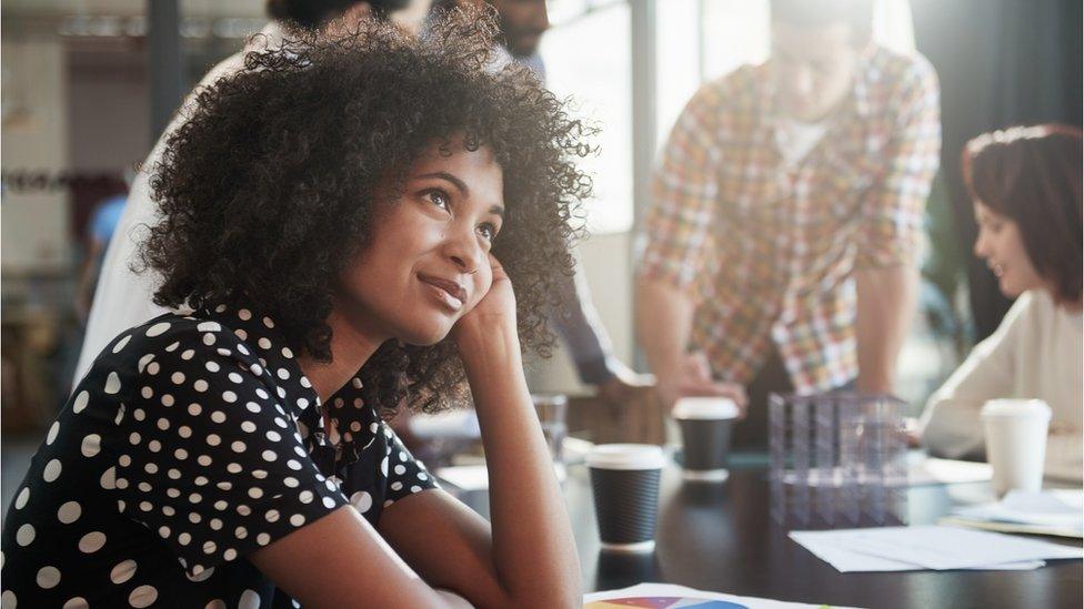 Woman daydreaming during boring meeting