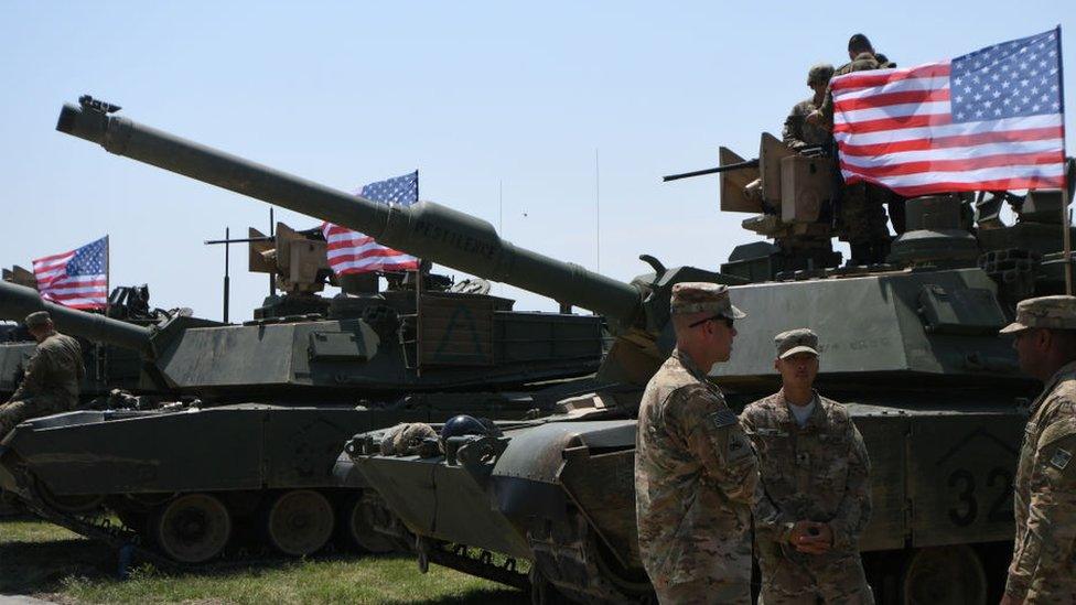 US soldiers stand by Abrams Battle Tanks bearing the US flag prior to the opening ceremony of the joint multinational military exercise "Noble Partner 2017"