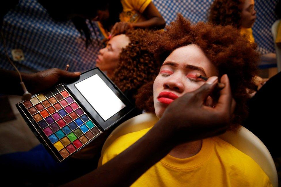 A make up artist works on a participant