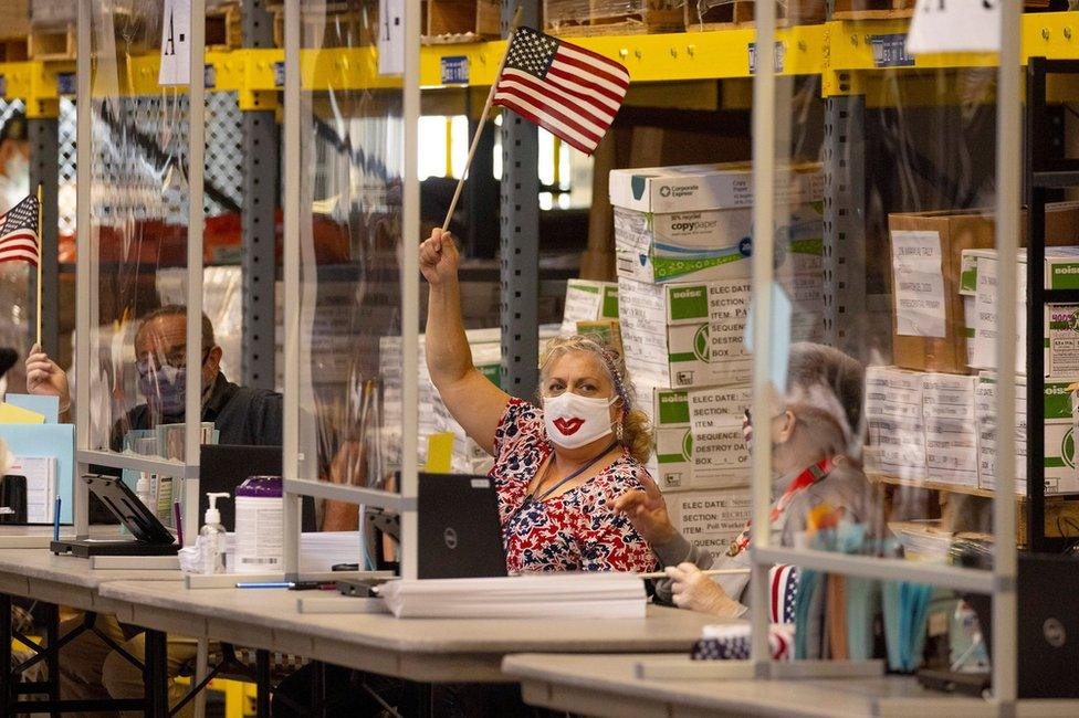 Poll workers wave US flags