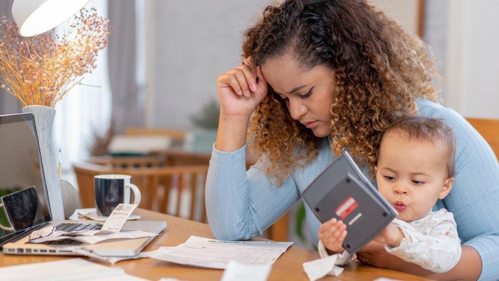 Woman with baby looking at budgets