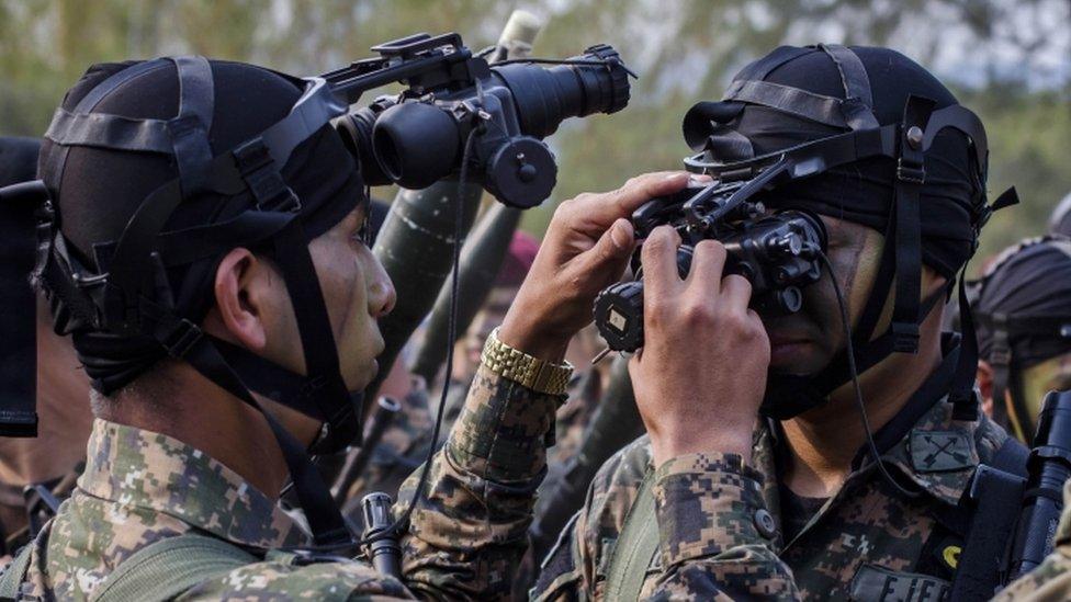 El Salvador army special forces try on their night vision goggles during a presentation to the press as part of a new stepped-up phase in the government's fight against gangs in San Salvador, El Salvador, Wednesday, April, 20, 2016.