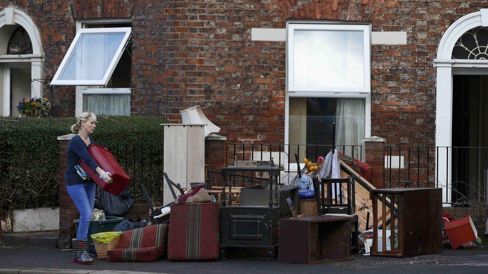 A woman brings her flood-hit furniture on to a Carlisle street