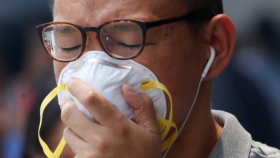 A man covers his face with a pollution mask in Singapore (26 Aug 2016)