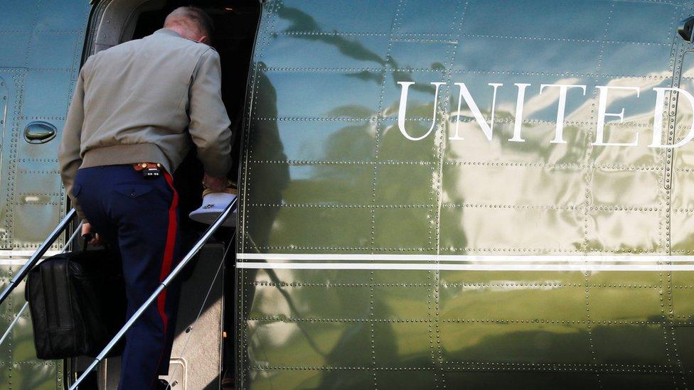 A US marine carries the nuclear football onto a helicopter in November