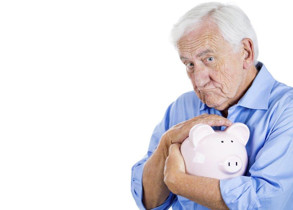 man protecting his piggy bank