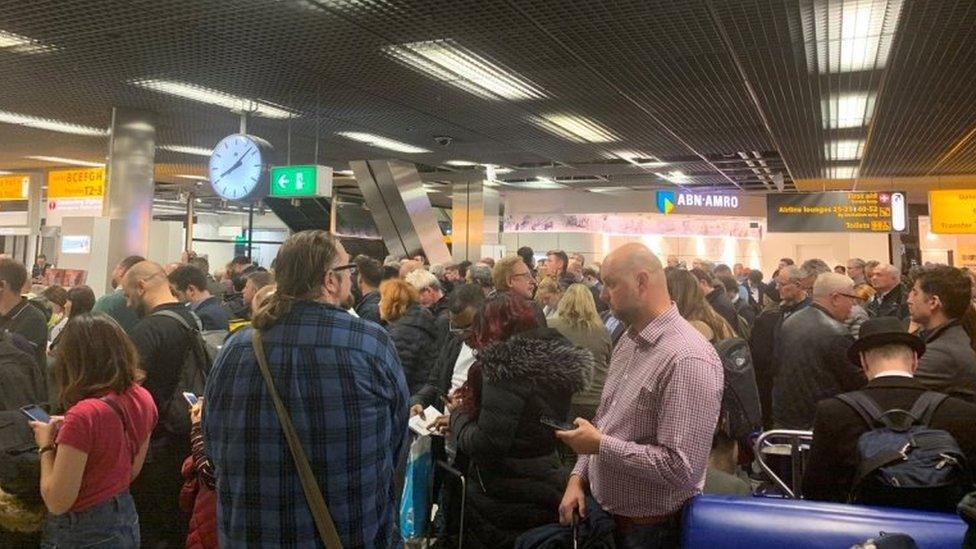 Passengers stand inside Amsterdam's Schiphol Airport during a security alert