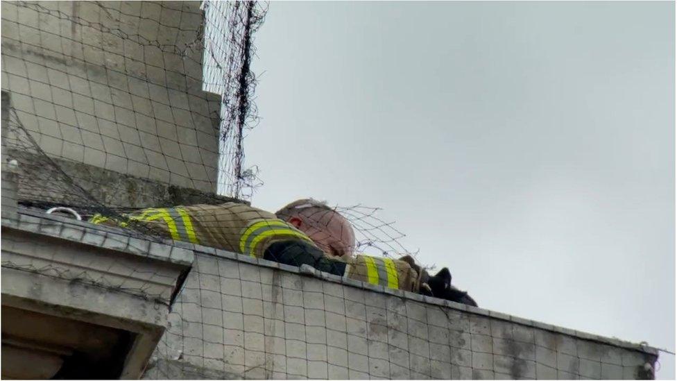 Fire fighter crawling on to the ledge