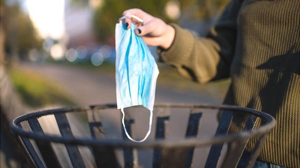 Woman throwing her mask away