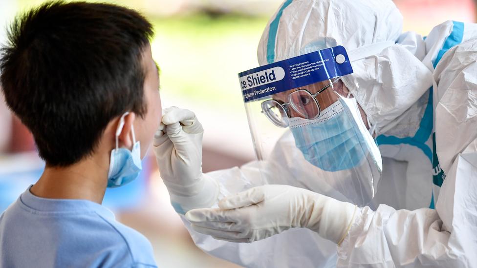 A medical worker collects a swab from a resident for nucleic acid testing amid the Covid-19 epidemic in Zhangjiajie, Hunan Province of China