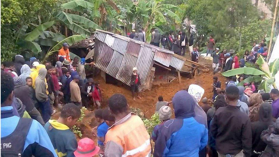 Locals surround a house that was covered by a landslide in the town of Mendi after an earthquake struck Papua New Guinea"s Southern Highlands in this image taken February 27, 2018