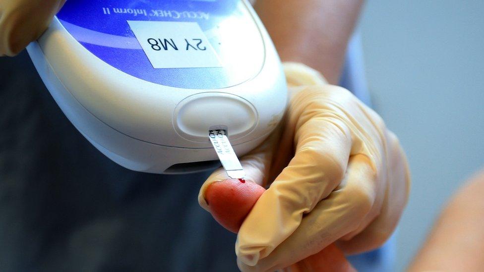 A nurse tests a patient for diabetes