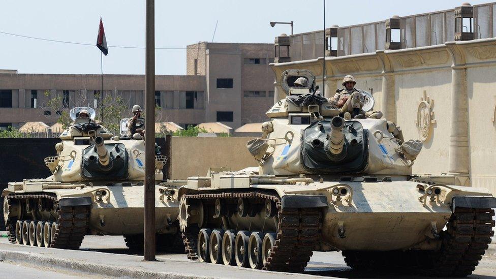 File photo showing Egyptian military tanks outside the police institute, near Cairo's Torah prison (10 April 2014)