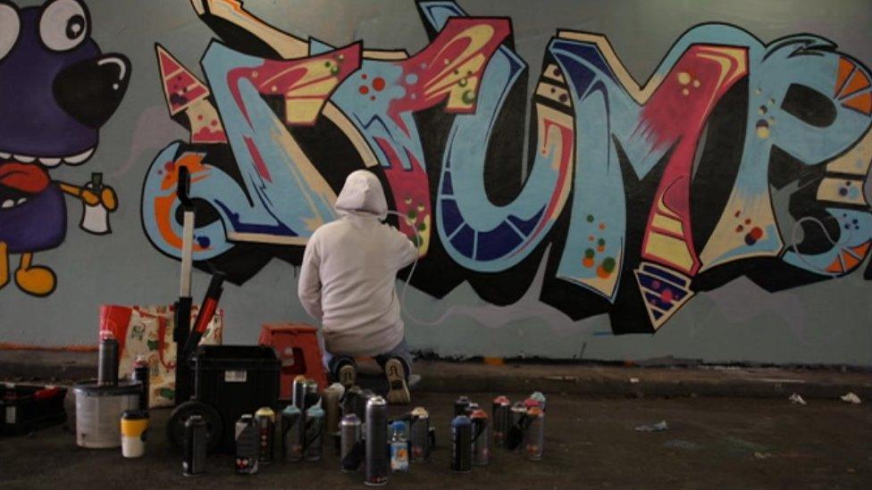 A graffiti artist painting a wall