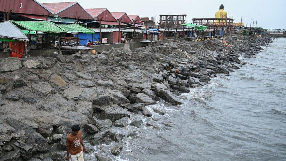 A man stands at the seafront in Sittwe in Myanmar's Rakhine state on May 13, 2023, ahead of the landfall of Cyclone Mocha.