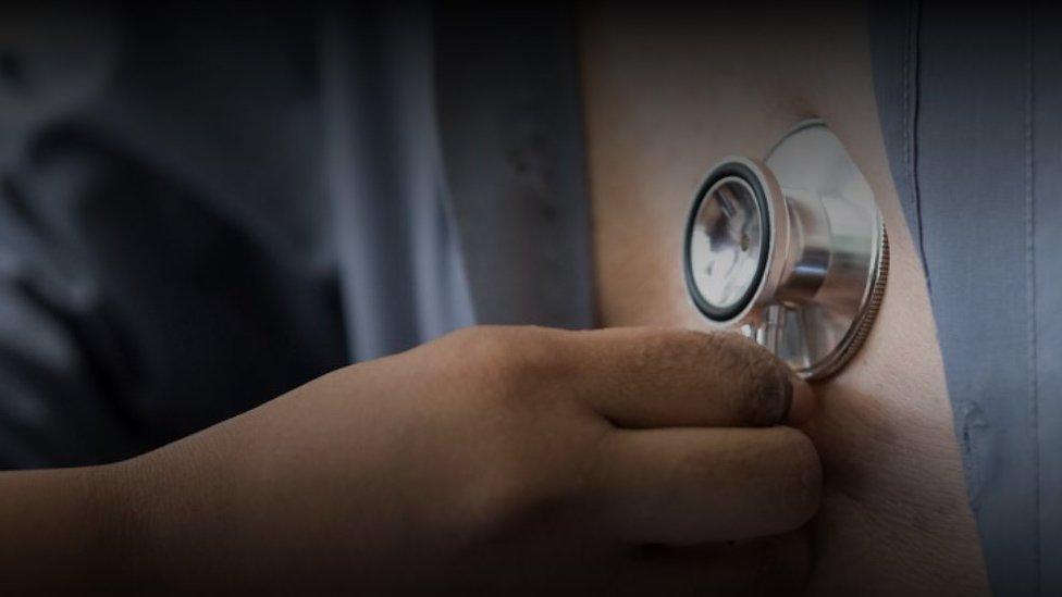 A stethoscope being held against a chest