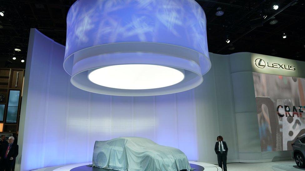 A security guard watches over a Lexus car during day one of the 2019 North American International Auto Show January 14, 2019 at the Cobo Center in Detroit, Michigan.