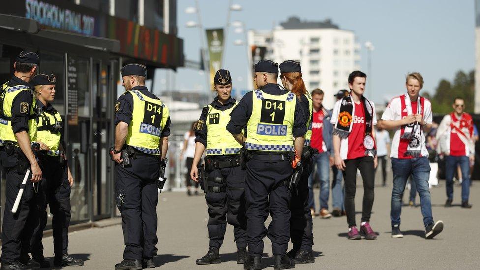 Police officers and Ajax fans outside the Friends Arena stadium in Stockholm before the match