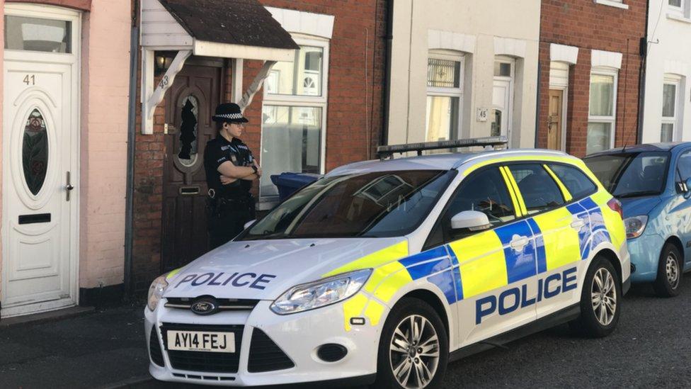 Police officer outside terraced house