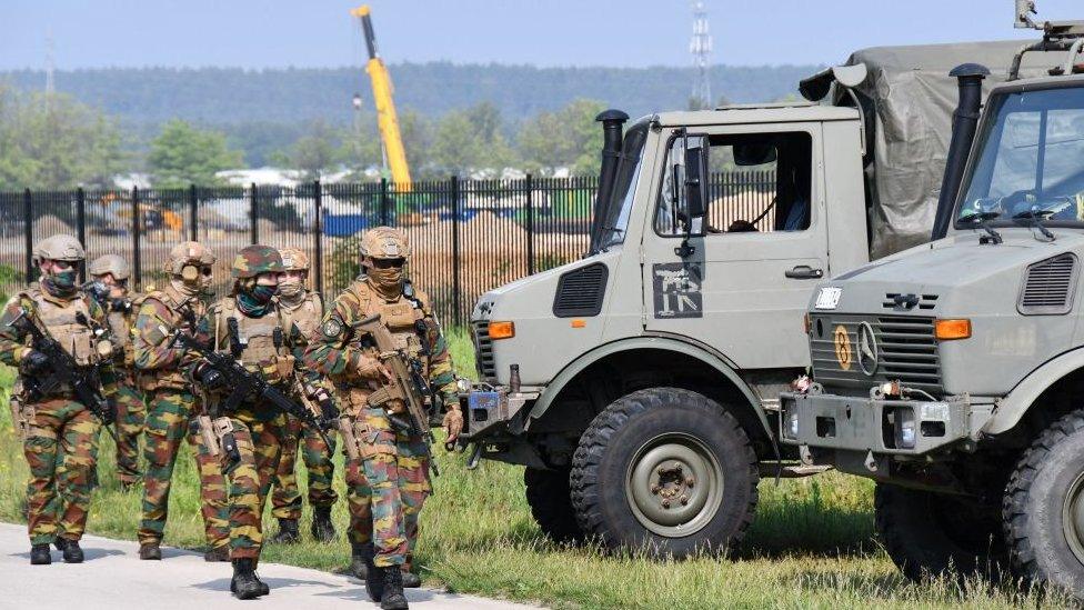 Heavily armed soldiers take part in an intensive sweeping of an area on the edge of the National Park Hoge Kempen in Maasmechelen on June 4, 2021, searching for Jürgen Conings