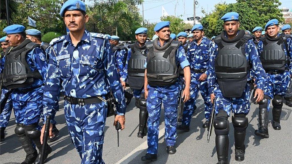 India's Rapid Action Force (RAF) personnel patrol along a street during a hunt for Sikh separatist, in Amritsar on March 23, 2023.