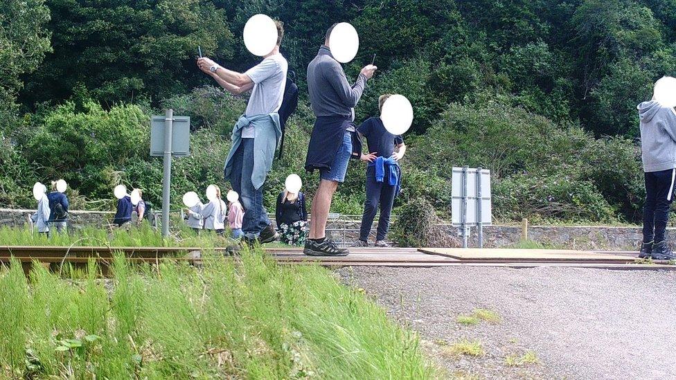 People post for selfies on a level crossing in Harlech