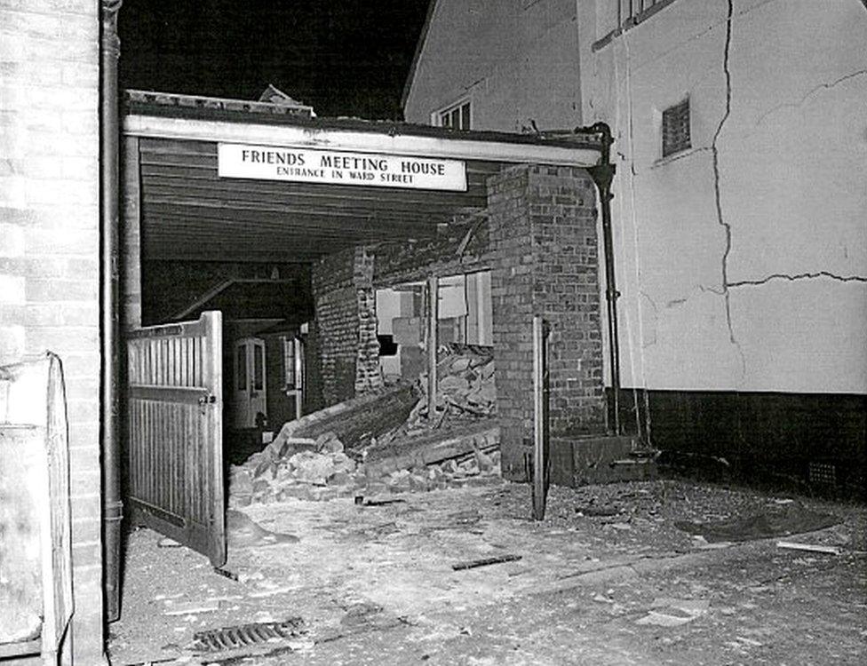 Pub brick wall that has collapsed into the neighbouring car port