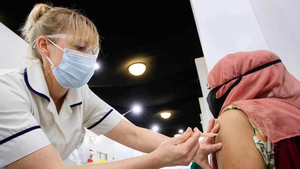 A woman receives an injection of the the Oxford/AstraZeneca coronavirus vaccine