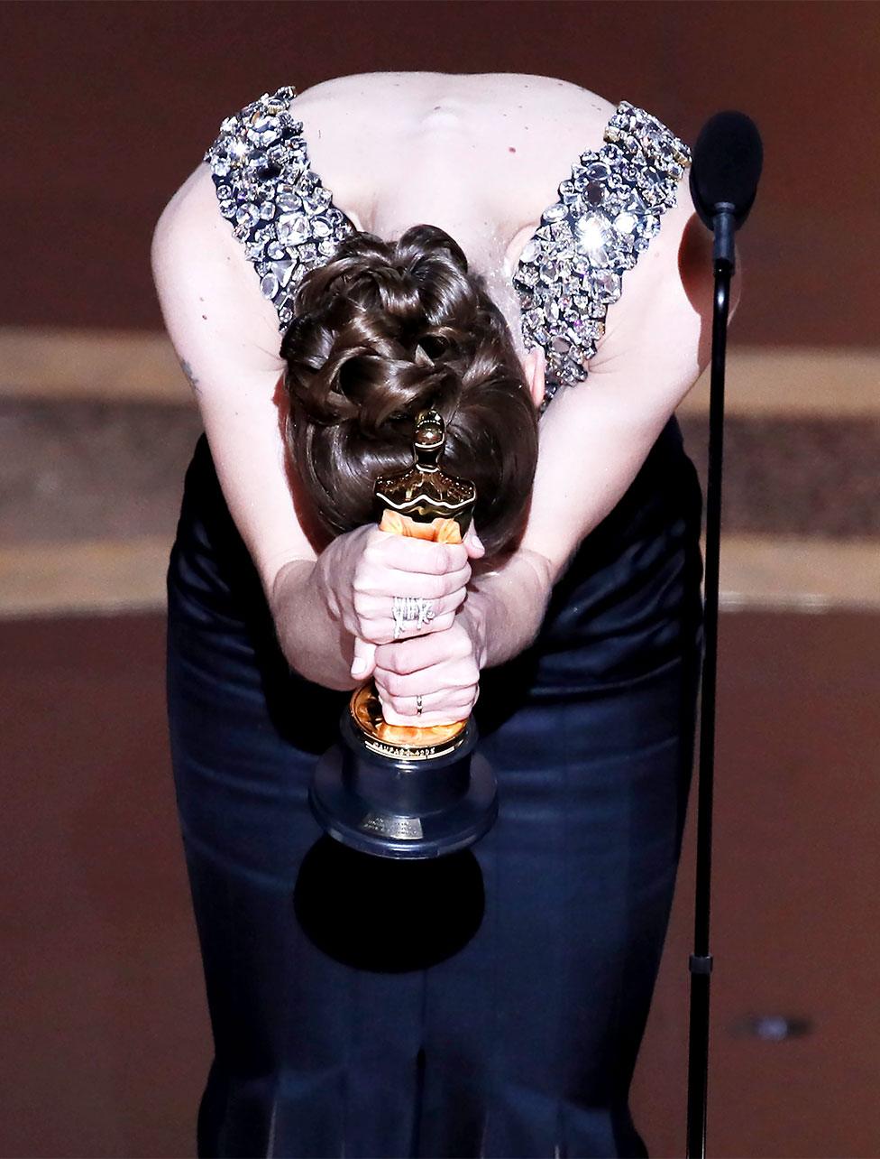 Hildur Guonadottir bows with her Oscar