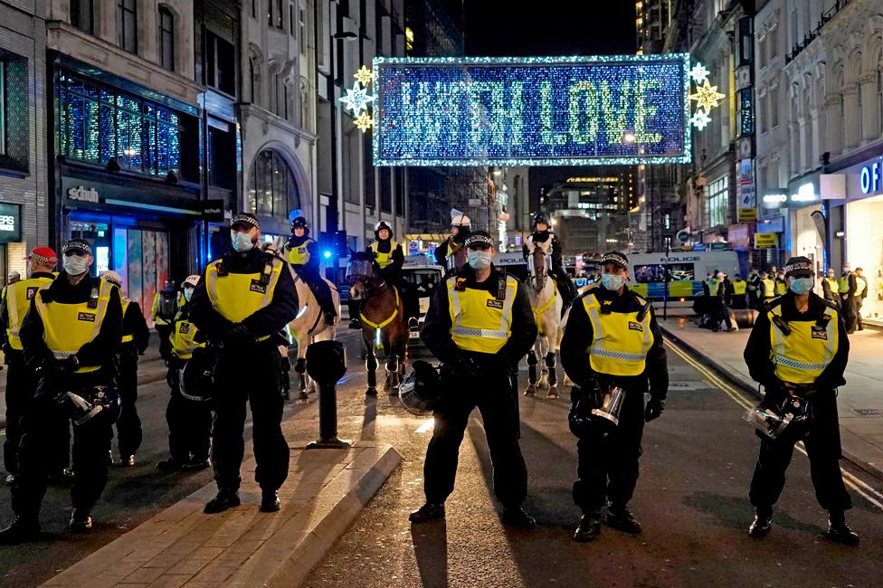 Police officers stand in a line, blocking off Oxford Street