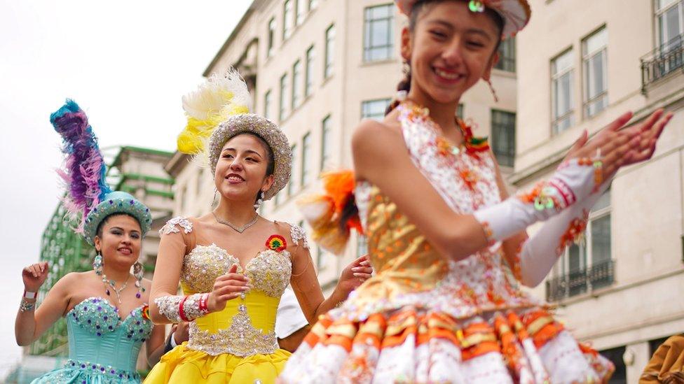 Dancers in colourful sequinned outfits perform