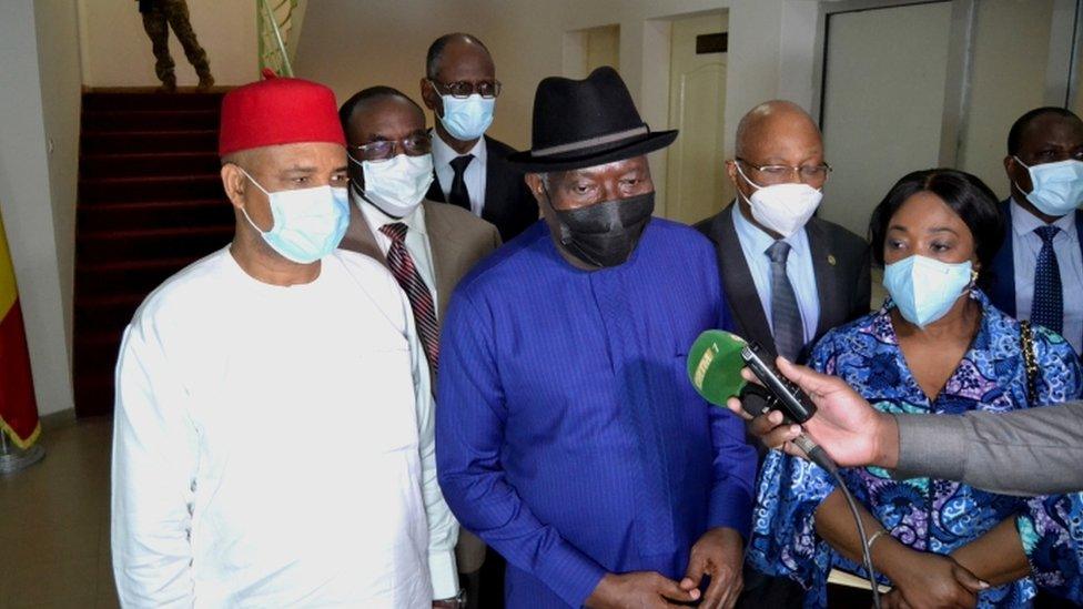 Former Nigerian President Goodluck Jonathan (C) and other members of the Ecowas delegation speak to journalists after meeting Col Goïta