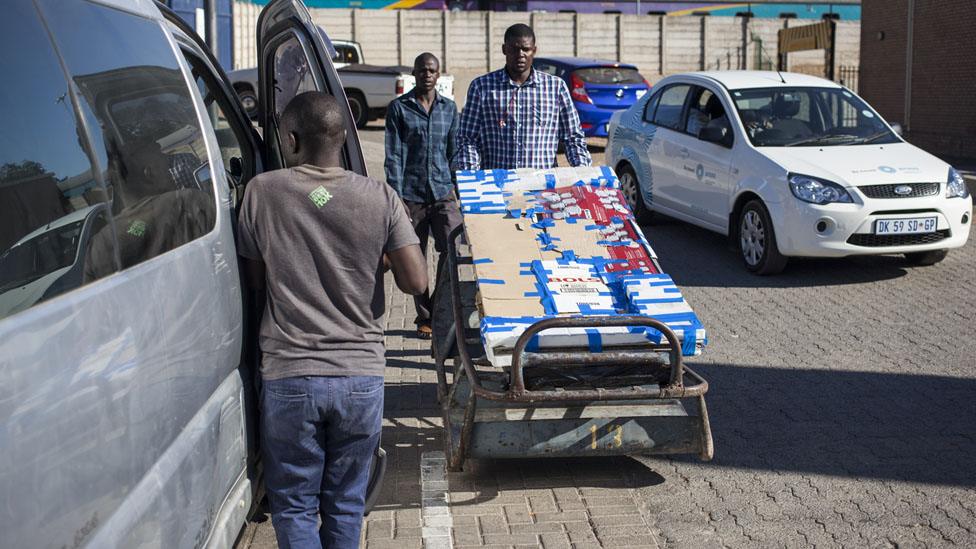 Man loading goods into a minibus